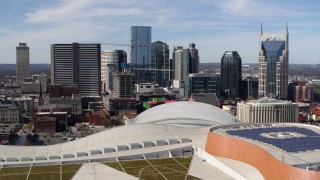 DX0002_117_039 - 5.7K aerial stock footage ascend near convention center roof for view of city's skyline, Downtown Nashville, Tennessee