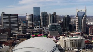 DX0002_117_041 - 5.7K aerial stock footage flyby and approach city's skyline behind the arena and hotel, Downtown Nashville, Tennessee