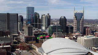 DX0002_117_042 - 5.7K aerial stock footage of flying by city's skyline, seen from the arena, Downtown Nashville, Tennessee