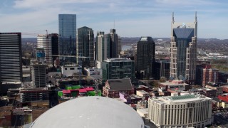 DX0002_117_044 - 5.7K aerial stock footage of passing by city's skyline, seen from Bridgestone Arena, Downtown Nashville, Tennessee