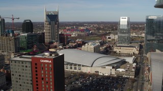 DX0002_119_016 - 5.7K aerial stock footage of arena between AT&T Building, Pinnacle skyscraper, descend near hotel, Downtown Nashville, Tennessee