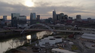 DX0002_119_032 - 5.7K aerial stock footage of a view of the Cumberland River, bridges, and city skyline at sunset, Downtown Nashville, Tennessee