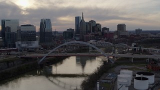 DX0002_119_042 - 5.7K aerial stock footage of the city skyline by bridges and Cumberland River at sunset, Downtown Nashville, Tennessee