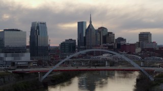 DX0002_120_001 - 5.7K aerial stock footage city skyline seen while passing bridge on Cumberland River at sunset, Downtown Nashville, Tennessee
