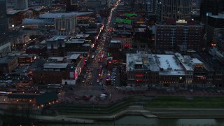 DX0002_120_023 - 5.7K aerial stock footage of orbiting Broadway, crowded with cars, at twilight, Downtown Nashville, Tennessee