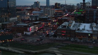 DX0002_120_024 - 5.7K aerial stock footage of orbiting Broadway, crowded with cars and pedestrians, at twilight, Downtown Nashville, Tennessee