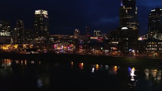 DX0002_121_022 - 5.7K aerial stock footage approach the end of Broadway with traffic at twilight, descend by the river in Downtown Nashville, Tennessee