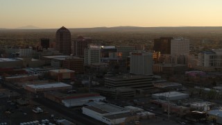 DX0002_122_036 - 5.7K stock footage aerial video of slowly flying by high-rise office buildings at sunset, Downtown Albuquerque, New Mexico