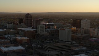 DX0002_122_039 - 5.7K aerial stock footage of slowly flying toward high-rise office buildings at sunset, Downtown Albuquerque, New Mexico