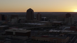 DX0002_122_047 - 5.7K aerial stock footage of an office tower and shorter hotel tower at sunset, Downtown Albuquerque, New Mexico