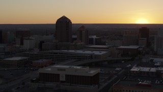 DX0002_122_048 - 5.7K aerial stock footage of orbiting an office tower and shorter hotel tower at sunset, Downtown Albuquerque, New Mexico