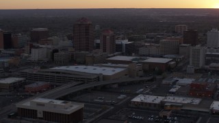DX0002_122_050 - 5.7K aerial stock footage slow orbit of an office tower and shorter hotel tower behind convention center at sunset, Downtown Albuquerque, New Mexico