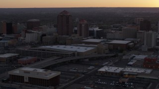 DX0002_122_051 - 5.7K aerial stock footage orbit office tower and shorter hotel tower behind convention center at sunset, Downtown Albuquerque, New Mexico