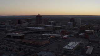 DX0002_123_006 - 5.7K aerial stock footage reverse view of office tower and hotel tower at sunset near office high-rises, Downtown Albuquerque, New Mexico