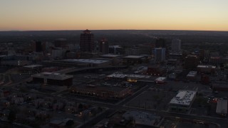 DX0002_123_010 - 5.7K aerial stock footage ascend and fly away from Albuquerque Plaza and Hyatt Regency at sunset, Downtown Albuquerque, New Mexico