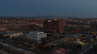 DX0002_123_021 - 5.7K aerial stock footage of a reverse view of a hospital complex at twilight in Albuquerque, New Mexico