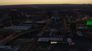 DX0002_123_024 - 5.7K aerial stock footage flying away from hotel and office buildings at twilight, Downtown Albuquerque, New Mexico