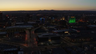 DX0002_123_028 - 5.7K aerial stock footage DoubleTree hotel with blue lighting near office buildings at twilight, Downtown Albuquerque, New Mexico