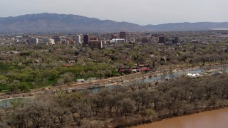 DX0002_124_005 - 5.7K stock footage aerial video approach high-rise office buildings while ascending over the Rio Grande and park, Downtown Albuquerque, New Mexico