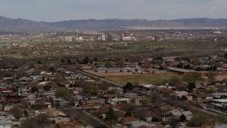 DX0002_126_006 - 5.7K stock footage aerial video passing by a suburban neighborhood with Downtown Albuquerque in the distance, New Mexico