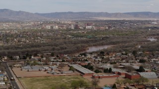 DX0002_126_008 - 5.7K aerial stock footage ascend over suburban neighborhood with Downtown Albuquerque beyond Rio Grande, New Mexico