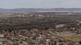 DX0002_126_009 - 5.7K aerial stock footage of Downtown Albuquerque beyond Rio Grande, seen from suburban homes, New Mexico