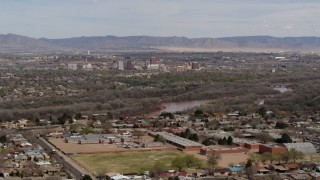 DX0002_126_012 - 5.7K aerial stock footage of Downtown Albuquerque and Rio Grande, seen while ascending from suburban homes, New Mexico