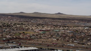 DX0002_126_014 - 5.7K aerial stock footage of suburban neighborhood and elementary school across freeway in Albuquerque, New Mexico