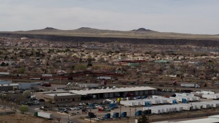 DX0002_126_015 - 5.7K aerial stock footage of suburban neighborhood across freeway, descend near warehouse building in Albuquerque, New Mexico