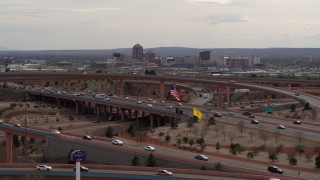 DX0002_126_019 - 5.7K stock footage aerial video ascend past freeway interchange to focus on Downtown Albuquerque, New Mexico
