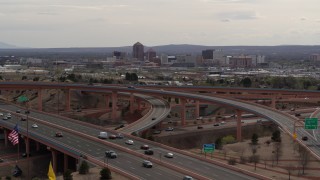 DX0002_126_021 - 5.7K aerial stock footage of Downtown Albuquerque seen while flying by freeway interchange, New Mexico