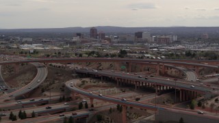DX0002_126_023 - 5.7K aerial stock footage of Downtown Albuquerque seen while passing freeway interchange traffic, New Mexico