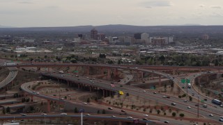 DX0002_126_026 - 5.7K aerial stock footage of Downtown Albuquerque seen while descending near freeway interchange traffic, New Mexico