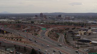 DX0002_126_028 - 5.7K aerial stock footage of Downtown Albuquerque buildings seen while descending past freeway interchange traffic, New Mexico