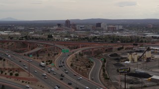 DX0002_126_031 - 5.7K aerial stock footage of Downtown Albuquerque buildings seen while descending by freeway interchange traffic, New Mexico