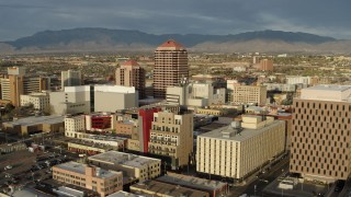 DX0002_127_027 - 5.7K aerial stock footage fly away from Albuquerque Plaza towering over city buildings, Downtown Albuquerque, New Mexico