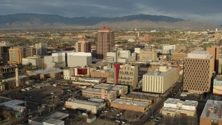 DX0002_127_028 - 5.7K aerial stock footage of flying by Albuquerque Plaza towering over city buildings, Downtown Albuquerque, New Mexico