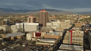 DX0002_127_030 - 5.7K stock footage aerial video wide orbit of Albuquerque Plaza towering over city buildings, Downtown Albuquerque, New Mexico