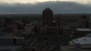 DX0002_128_002 - 5.7K aerial stock footage of a reverse view of office high-rise and hotel at sunset, Downtown Albuquerque, New Mexico