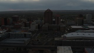DX0002_128_003 - 5.7K aerial stock footage of orbiting office high-rise beside hotel at sunset, Downtown Albuquerque, New Mexico