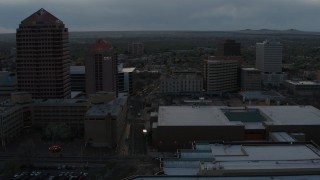 DX0002_128_009 - 5.7K aerial stock footage of office high-rise, hotel, and Kiva Auditorium at sunset during descent, Downtown Albuquerque, New Mexico