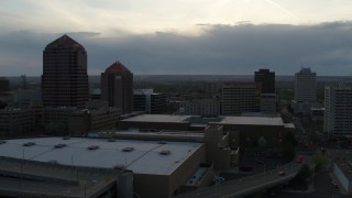 DX0002_128_010 - 5.7K aerial stock footage reverse view of office tower, hotel, Kiva Auditorium, convention center at sunset, Downtown Albuquerque, New Mexico