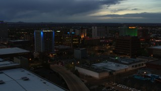DX0002_128_021 - 5.7K aerial stock footage orbit and fly away from hotel and office buildings at twilight, Downtown Albuquerque, New Mexico