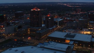 DX0002_128_028 - 5.7K aerial stock footage slow orbit of office high-rise, hotel and Kiva Auditorium at twilight, Downtown Albuquerque, New Mexico