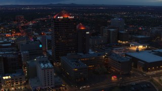 DX0002_128_030 - 5.7K aerial stock footage of an orbit of office high-rise and hotel at twilight, Downtown Albuquerque, New Mexico