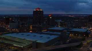 DX0002_128_032 - 5.7K aerial stock footage fly away from office high-rise, hotel, auditorium and reveal convention center at twilight, Downtown Albuquerque, New Mexico