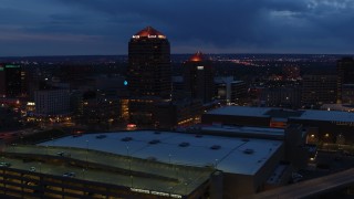 DX0002_128_033 - 5.7K aerial stock footage orbit office high-rise, hotel, seen from convention center at twilight, Downtown Albuquerque, New Mexico