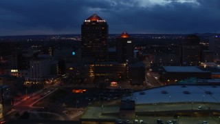 DX0002_128_034 - 5.7K aerial stock footage circling office high-rise beside hotel at twilight, Downtown Albuquerque, New Mexico
