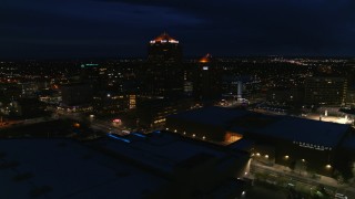 DX0002_128_044 - 5.7K aerial stock footage orbiting office high-rise beside hotel at twilight, reveal auditorium, Downtown Albuquerque, New Mexico