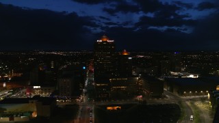 DX0002_128_048 - 5.7K aerial stock footage circling an office high-rise and hotel at twilight, Downtown Albuquerque, New Mexico